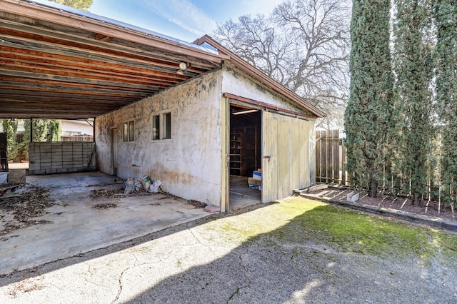 view of outbuilding with an outbuilding, a carport, and an exterior structure