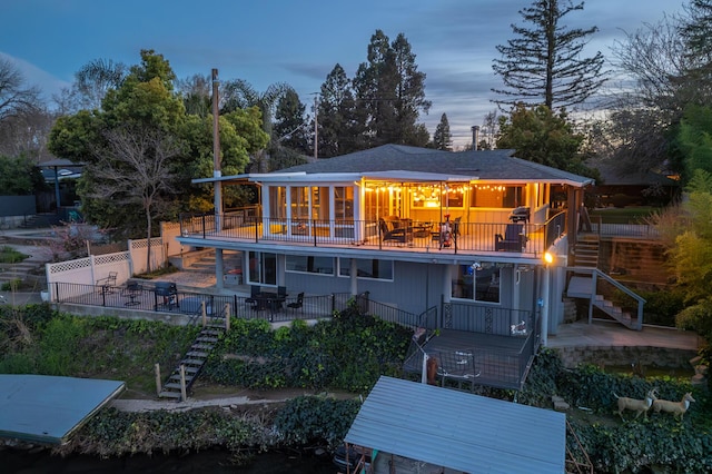 rear view of house featuring stairway, a patio area, fence, and a balcony