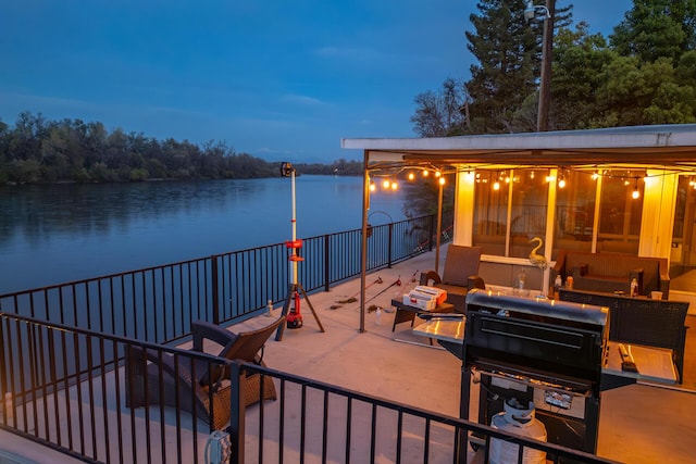 patio terrace at dusk featuring a water view