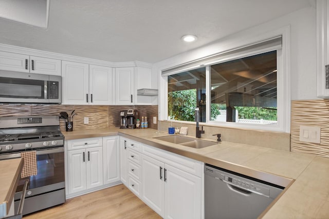 kitchen featuring white cabinetry, stainless steel appliances, and light countertops