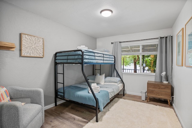 bedroom with baseboards and wood finished floors