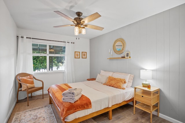 bedroom with ceiling fan, wood finished floors, and baseboards