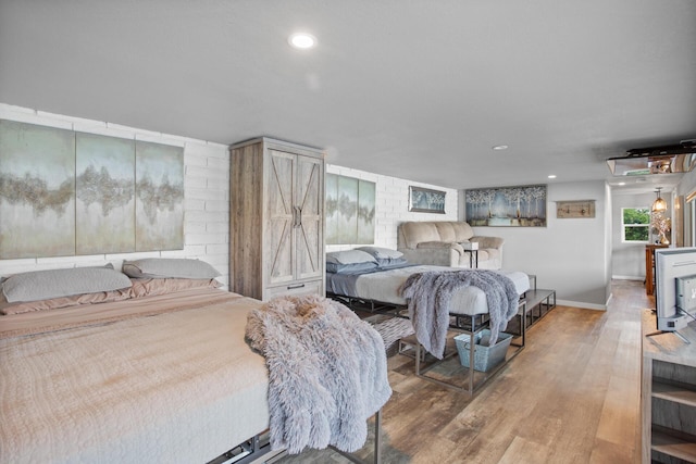 bedroom featuring baseboards, wood finished floors, and recessed lighting