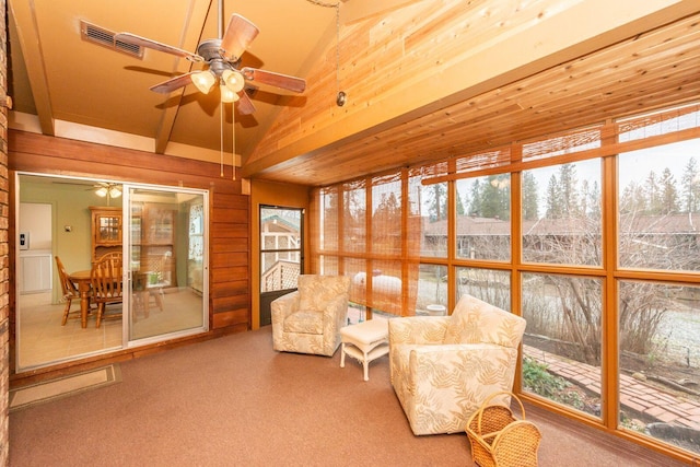 sunroom featuring lofted ceiling, visible vents, and a ceiling fan