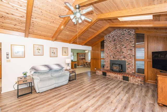 living room with lofted ceiling with beams, wood ceiling, a ceiling fan, and wood finished floors