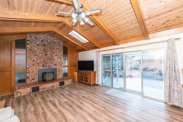 unfurnished living room with light wood finished floors, visible vents, a ceiling fan, wood ceiling, and vaulted ceiling with skylight