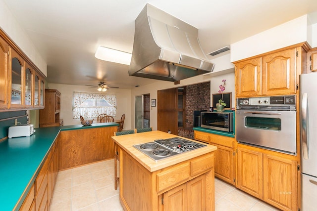 kitchen featuring island range hood, stainless steel appliances, visible vents, a center island, and glass insert cabinets