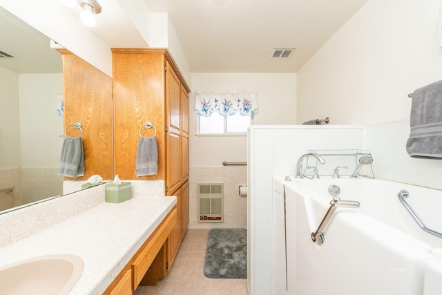 full bath featuring tile patterned flooring, visible vents, a bath, and vanity