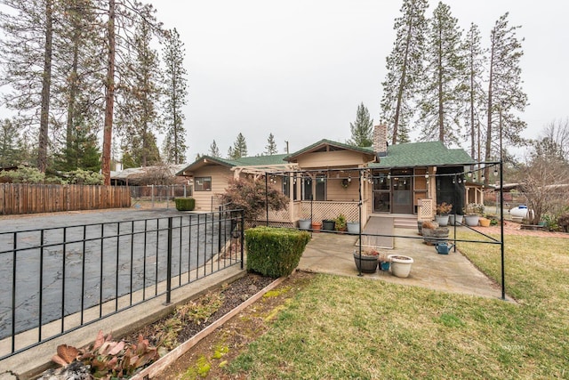 view of front of house featuring a patio, a front yard, and fence private yard