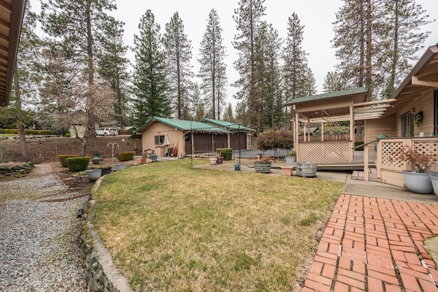 view of yard with fence, a deck, and a patio