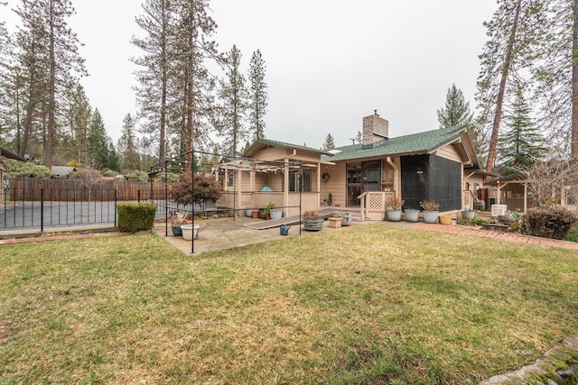 back of house featuring a patio, a yard, a chimney, and fence