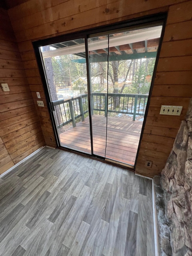 doorway to outside featuring wood walls and wood finished floors