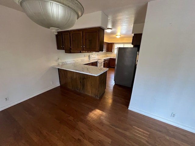 kitchen featuring a peninsula, white electric range, light countertops, freestanding refrigerator, and dark wood-style floors