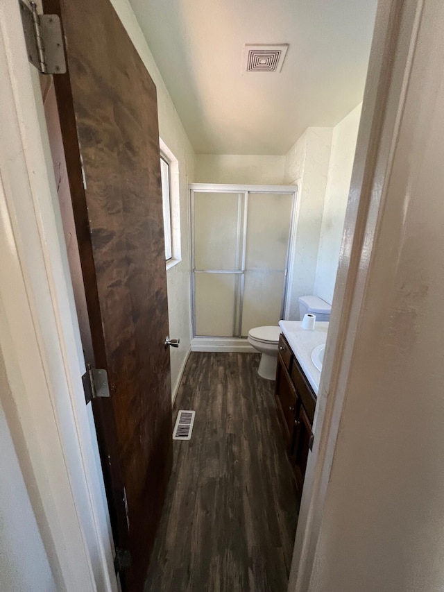 full bathroom with visible vents, a shower stall, vanity, and wood finished floors