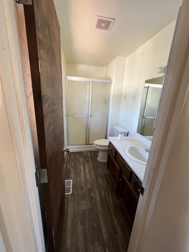 full bath featuring vanity, a stall shower, wood finished floors, and visible vents