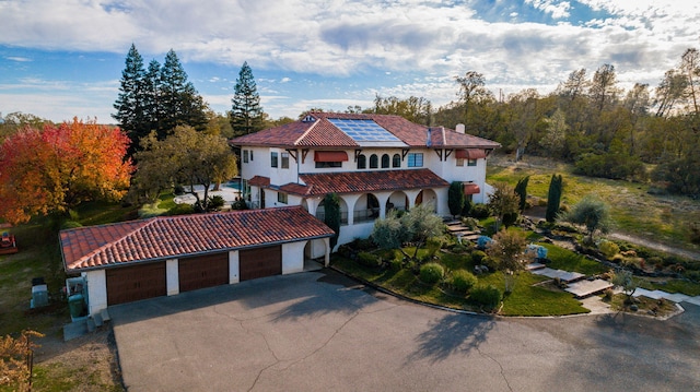 mediterranean / spanish home with a chimney, driveway, and a tiled roof