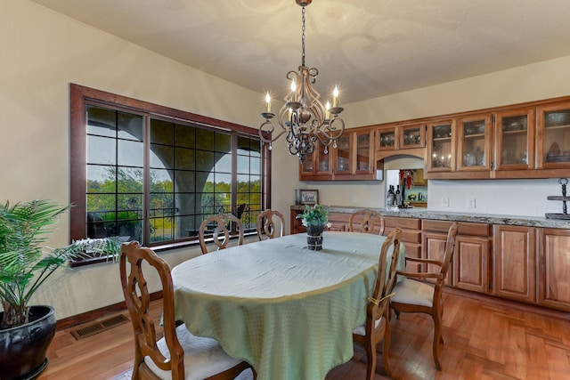 dining area with visible vents and an inviting chandelier