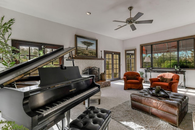 living area featuring a ceiling fan, carpet, a fireplace, and plenty of natural light