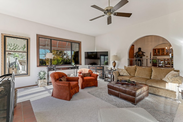 living room with arched walkways, carpet floors, ceiling fan, and baseboards