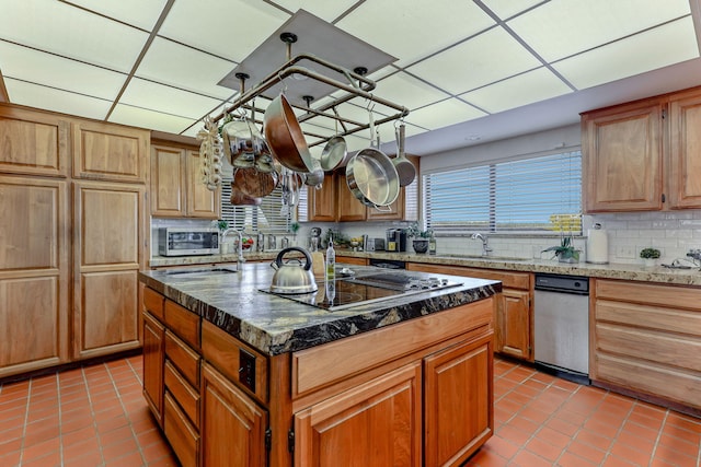 kitchen with light tile patterned floors, a paneled ceiling, black electric cooktop, and decorative backsplash