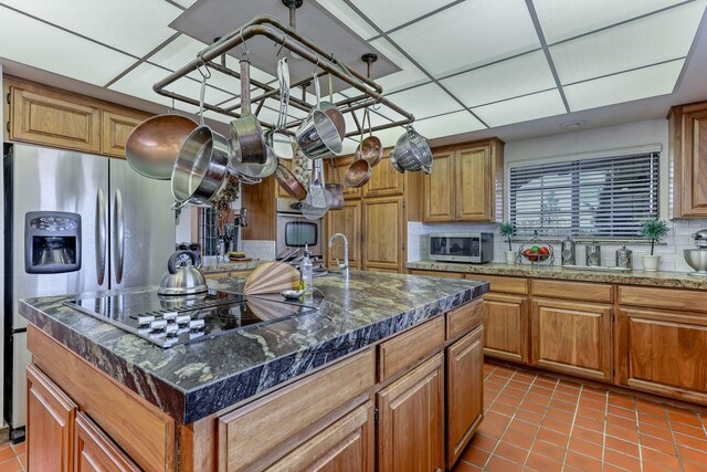 kitchen featuring light tile patterned floors, tasteful backsplash, stainless steel microwave, and a paneled ceiling