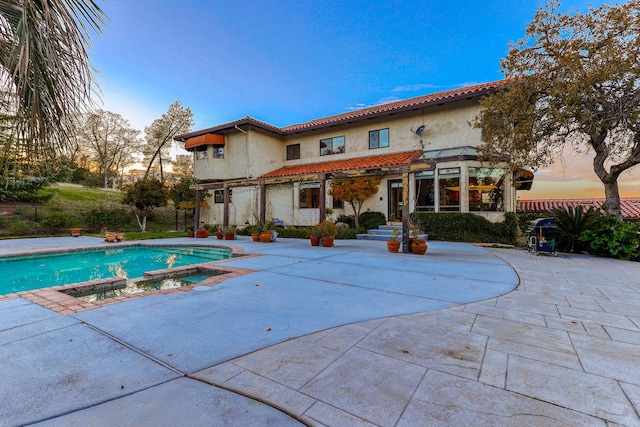 view of swimming pool with a pool with connected hot tub and a patio