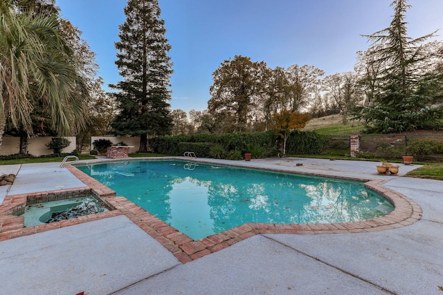 view of pool with a patio, fence, a fenced in pool, and an in ground hot tub