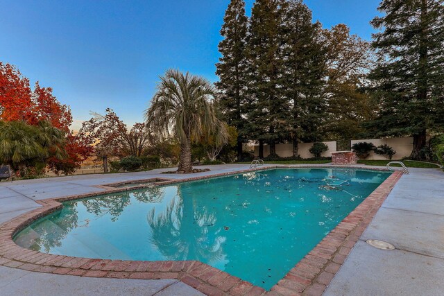 view of swimming pool with a patio area, fence, and a fenced in pool