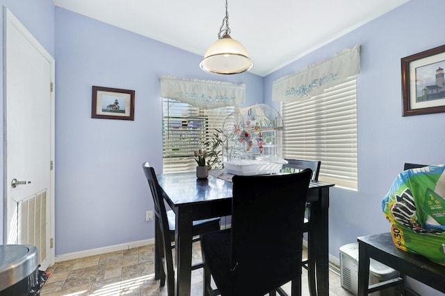 dining area featuring baseboards, stone finish floor, and a wealth of natural light