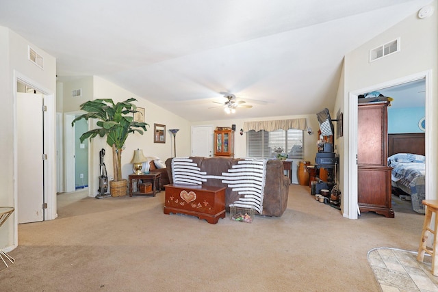 carpeted living area featuring lofted ceiling, ceiling fan, and visible vents