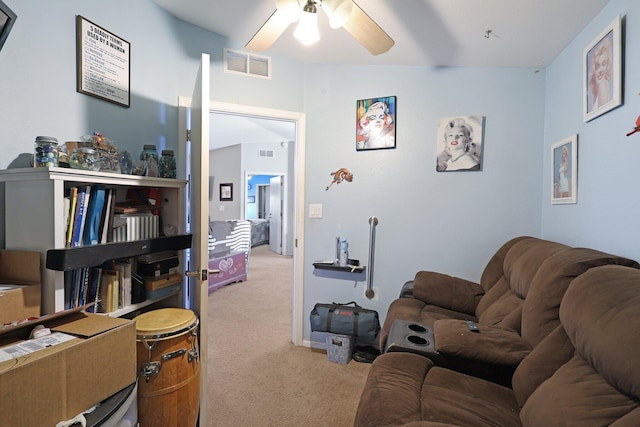 living area with light carpet, visible vents, and a ceiling fan