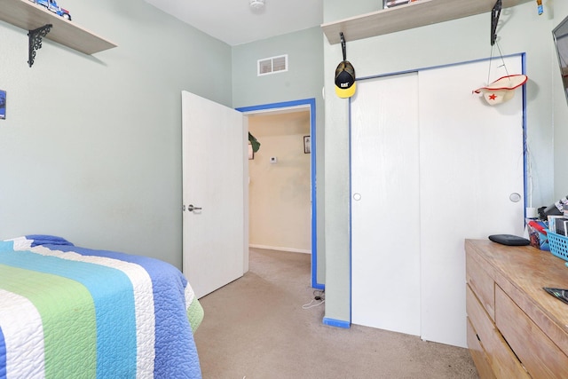 bedroom with a closet, visible vents, and light carpet