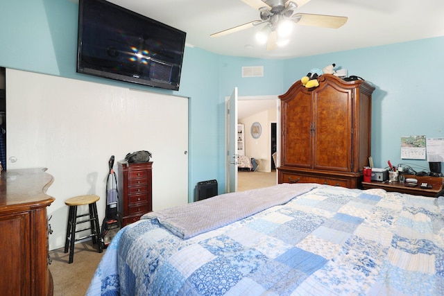 carpeted bedroom featuring a ceiling fan and visible vents