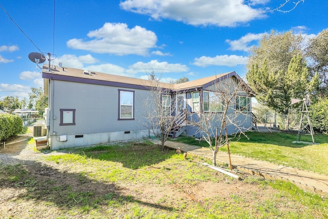 exterior space with crawl space, fence, central AC unit, and a lawn