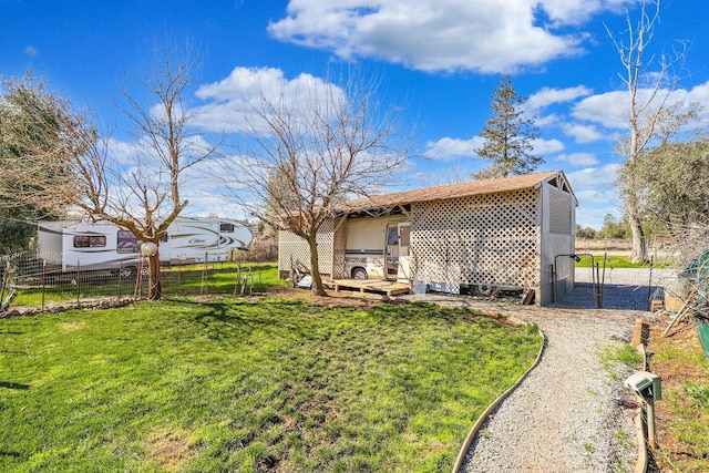 rear view of house featuring fence and a lawn