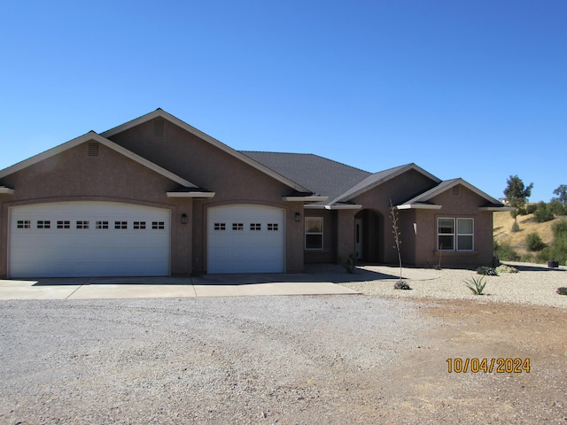 single story home featuring a garage, driveway, and stucco siding