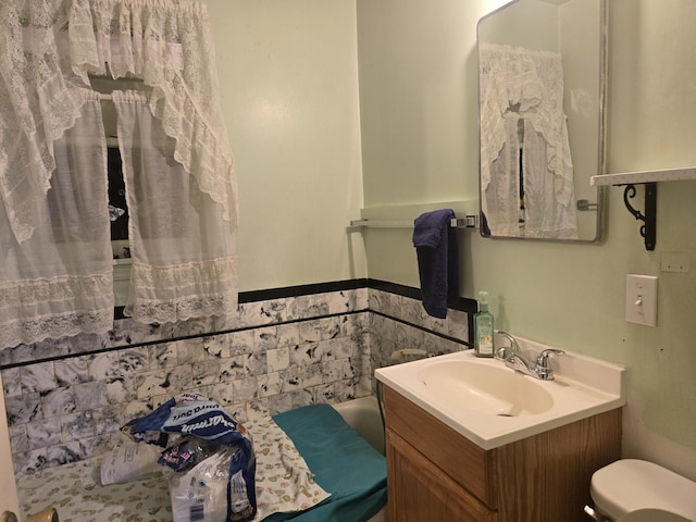 full bath with a washtub, vanity, and toilet