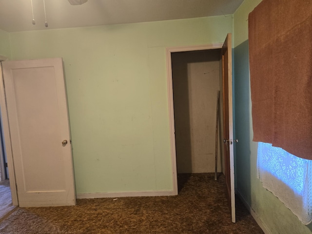 spare room featuring dark colored carpet