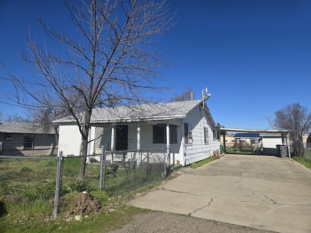 view of front of house featuring a fenced front yard, driveway, and a carport