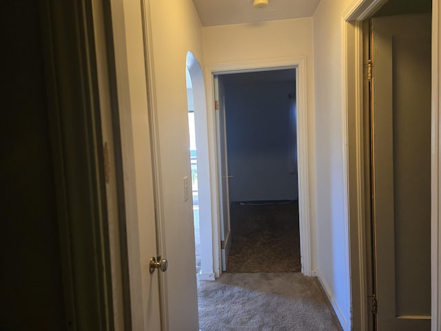 hallway with carpet floors and baseboards