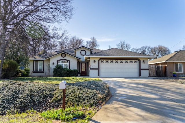 ranch-style home with an attached garage, fence, concrete driveway, and stucco siding