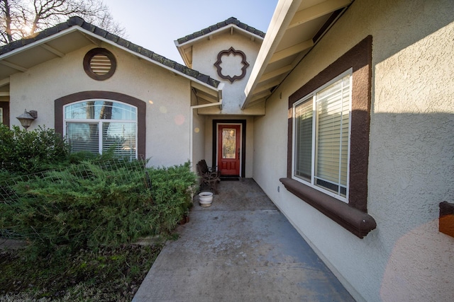 entrance to property featuring stucco siding