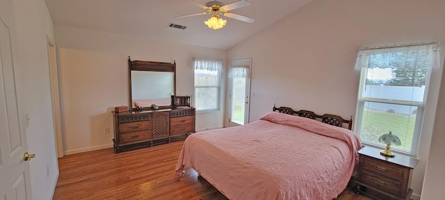 bedroom with baseboards, visible vents, ceiling fan, wood finished floors, and vaulted ceiling