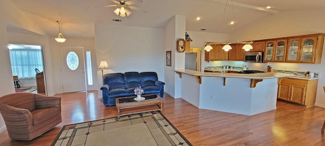 kitchen featuring open floor plan, stainless steel appliances, a breakfast bar, and visible vents