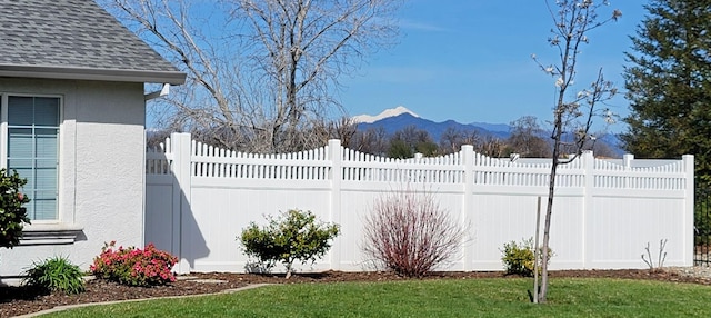 view of yard featuring fence and a mountain view