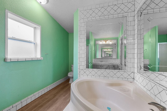 14839 Lamoine Dr, Redding, CA 96003 - full bath featuring wood finished floors, toilet, a bath, and a textured ceiling