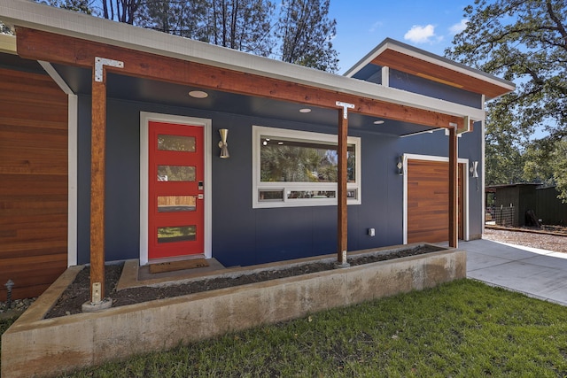 doorway to property with a garage and concrete driveway