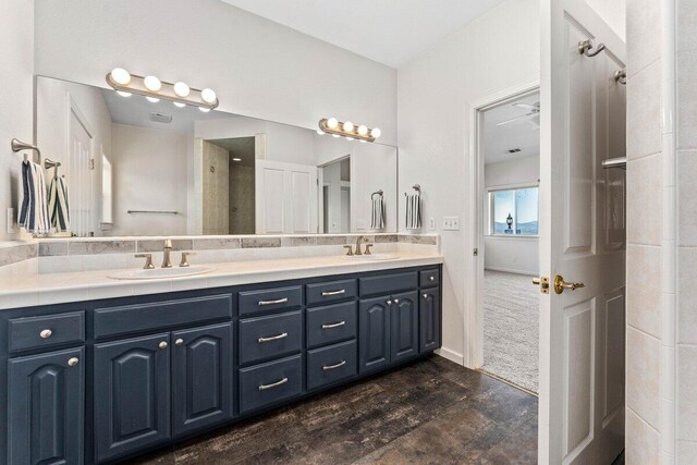 bathroom featuring double vanity, wood finished floors, and a sink