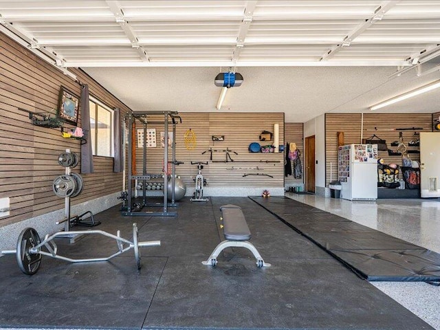 19907 Hidden Hills Rd, Cottonwood, CA 96022 - garage with freestanding refrigerator, a garage door opener, and wooden walls