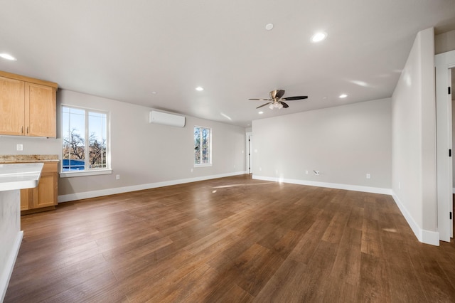 unfurnished living room featuring recessed lighting, a wall mounted AC, dark wood-type flooring, a ceiling fan, and baseboards